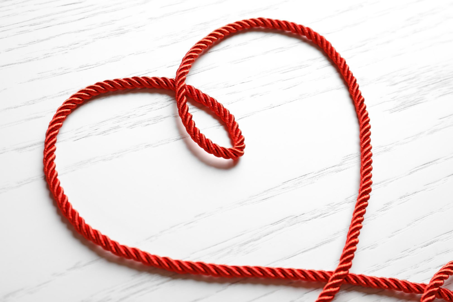 Corde rouge formant un cœur symbolisant l’attachement anxieux et la peur de l’abandon